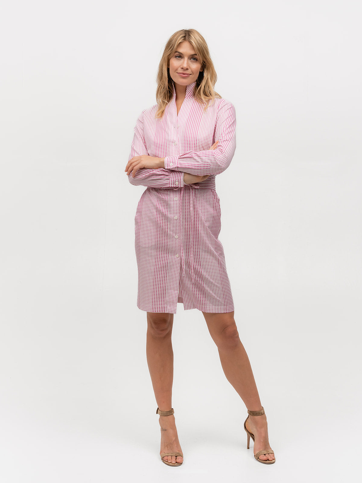 Woman wearing a pink polka dot shirt dress with heels